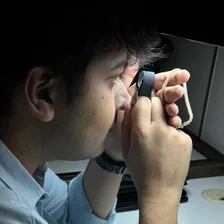 Examining a diamond chain through a jeweller’s loupe